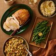 Sliced turkey breast roast with stuffing, mashed potatoes, green beans and gravy, festive holiday meal kit.